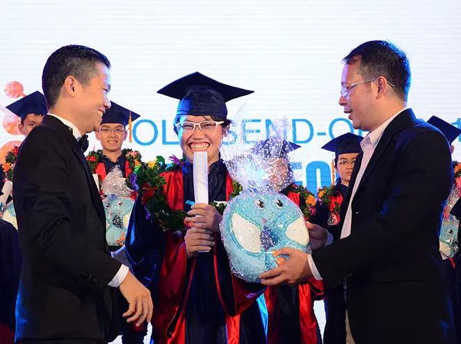 Thầy Nguyễn Chí Hiếu (trái) và anh Phạm Anh Khoa, Chủ tịch HĐQT YOLA (phải) trao quà cho học viên YOLA trong buổi lễ YOLA Send-off 2015"